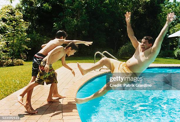 boys pushing father into swimming pool - pushman stock pictures, royalty-free photos & images