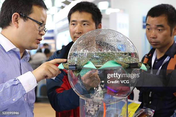 Visitors and exhibitors look new nano-fiber material which's air-permeable but impervious to water during the opening ceremony of the 4th China...