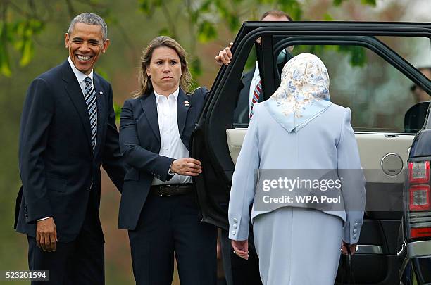 Queen Elizabeth II gets into a car as US President Barack Obama looks on after he landed by helicopter at Windsor Castle for a private lunch on April...