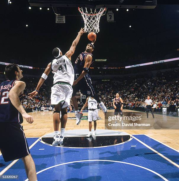 Vince Carter of the New Jersey Nets goes for a dunk against Eddie Griffin of the Minnesota Timberwolves during the game at Target Center on February...