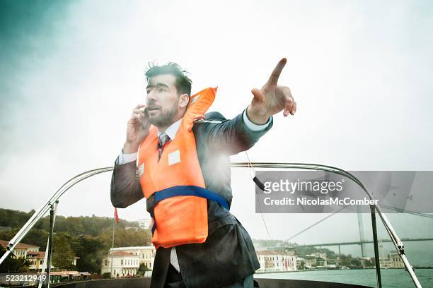 businessman manages crisis in storm concept - life jacket stock pictures, royalty-free photos & images