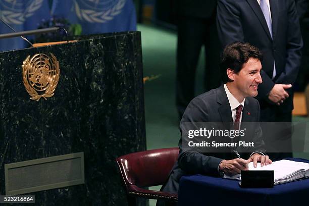 Canadian Prime Minister Justin Trudeau signs the accord at the United Nations Signing Ceremony for the Paris Agreement climate change accord that...