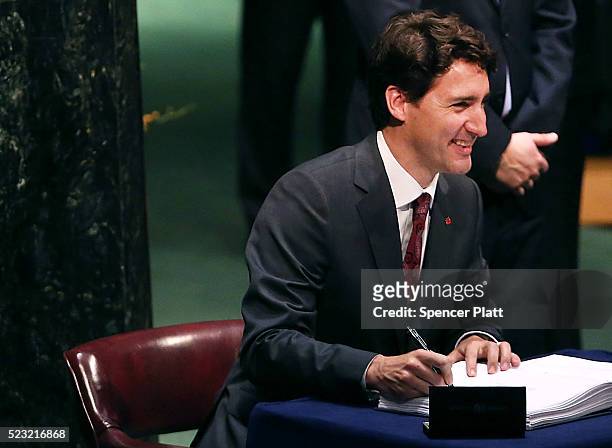 Canadian Prime Minister Justin Trudeau signs the accord at the United Nations Signing Ceremony for the Paris Agreement climate change accord that...