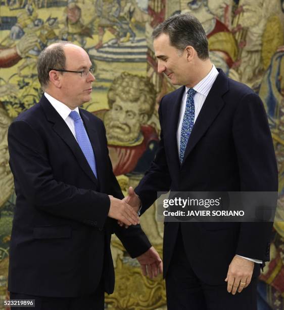 Spain's King Felipe VI and Monaco's Prince Albert II shake hands as they pose for media prior to a meeting at the Zarzuela Palace in Madrid, on April...