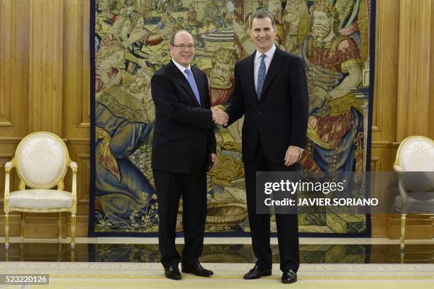 Spain's King Felipe VI and Monaco's Prince Albert II shake hands as they pose for media prior to a meeting at the Zarzuela Palace in Madrid, on April...