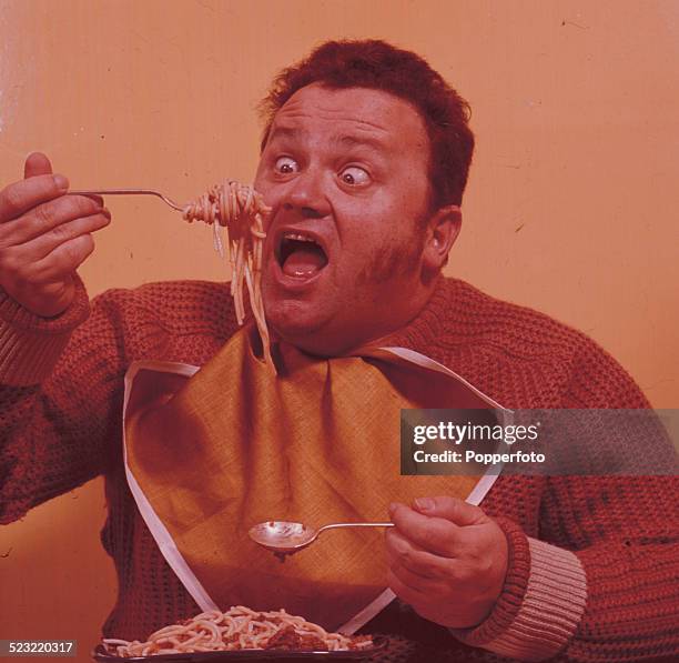 Welsh comedian and singer Harry Secombe pictured eating a plate of spaghetti bolognese in 1964.