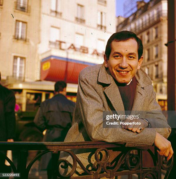 American musician and actor, Trini Lopez pictured standing outside a hotel in Paris in 1964.