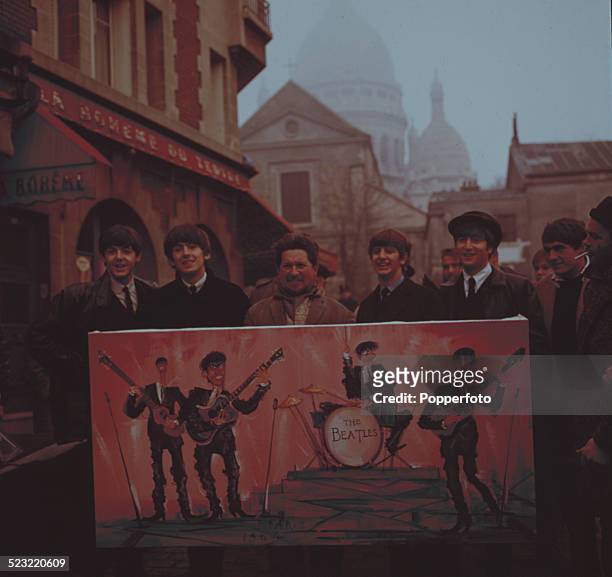 English group The Beatles posed with a street artist holding a painting of the band on a street in Montmartre, Paris in January 1964. From left to...