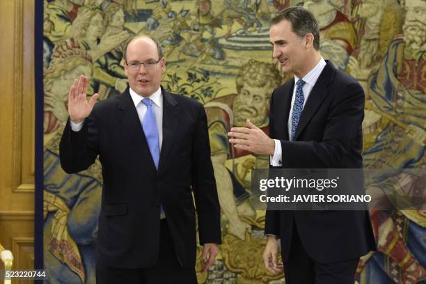 Spain's King Felipe VI and Monaco's Prince Albert II wave as they pose for media prior to a meeting at the Zarzuela Palace in Madrid, on April 22,...
