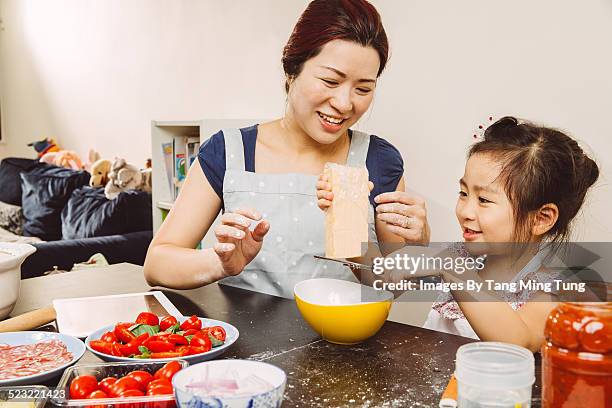 mom & toddler making pizza joyfully together - hartkäse stock-fotos und bilder