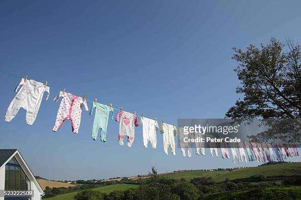 lots of baby grows on a washing line - sparkdräkt bildbanksfoton och bilder