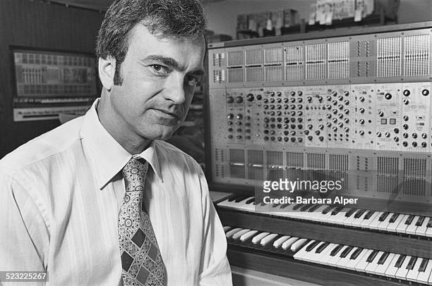 Portrait of businessman David S. Spencer, Executive Vice President of ARP Instruments Inc, as he poses with one of the company's synthesizers,...