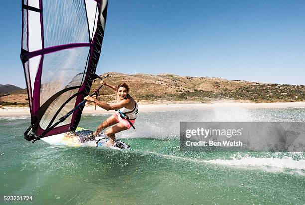 young woman windsurfing and having fun - windsurf stockfoto's en -beelden