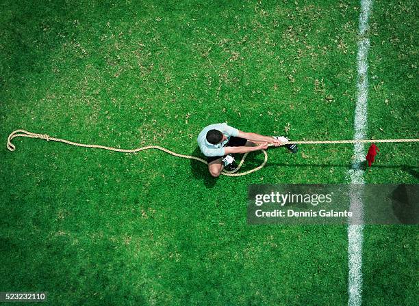 man playing tug of war - lucha de la cuerda fotografías e imágenes de stock