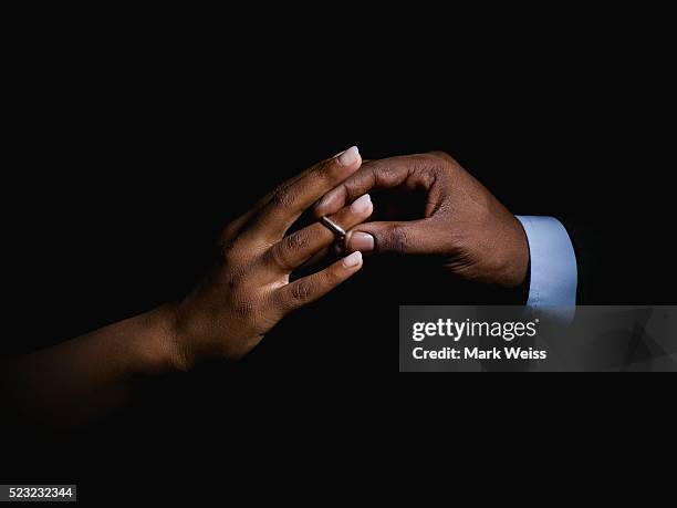 man placing ring on woman's finger - finger ring stock pictures, royalty-free photos & images