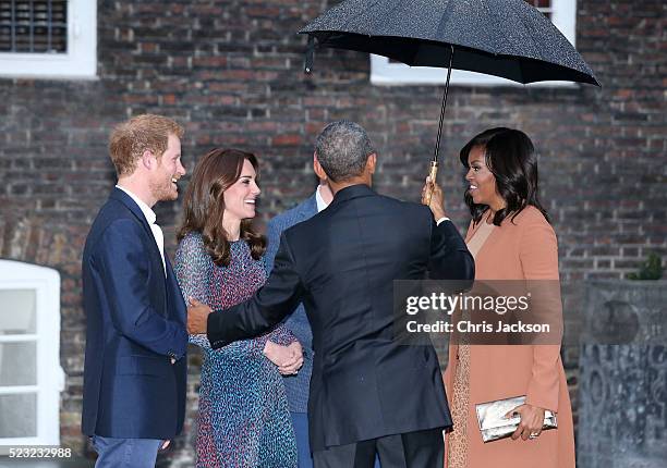Prince Harry, Catherine, Duchess of Cambridge, US President Barack Obama and First Lady Michelle Obama speak as they attend a dinner at Kensington...