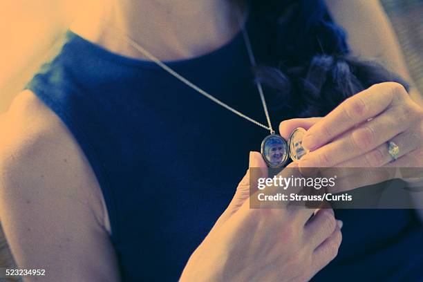 holding locket with parents' photos - choker necklace stock pictures, royalty-free photos & images