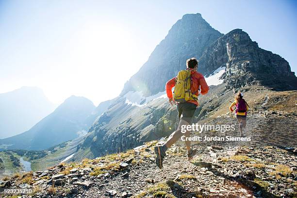 man and woman trail running, lewis range, rocky mountains, glacier national park, usa - trailrunning stock-fotos und bilder
