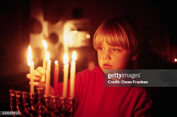 tunui franken placing candles in a menorah - chanoeka stockfoto's en -beelden