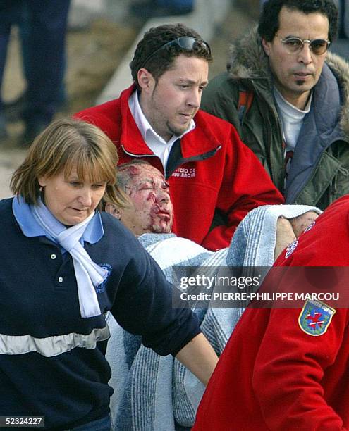 Rescue workers evacuate an injured commuter from the Atocha railway station in Madrid 11 March 2004. Relatives of many of those killed in the March...