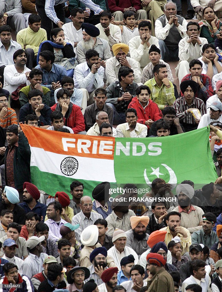 Indian and Pakistani cricket fans sit ne