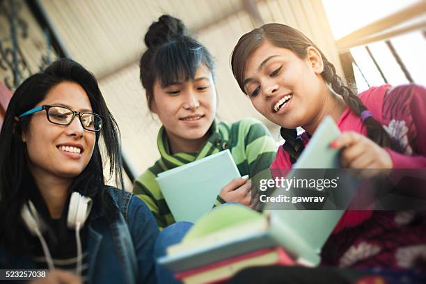 late teen happy girl students of different ethnicity studying together. - indian college girls stock pictures, royalty-free photos & images