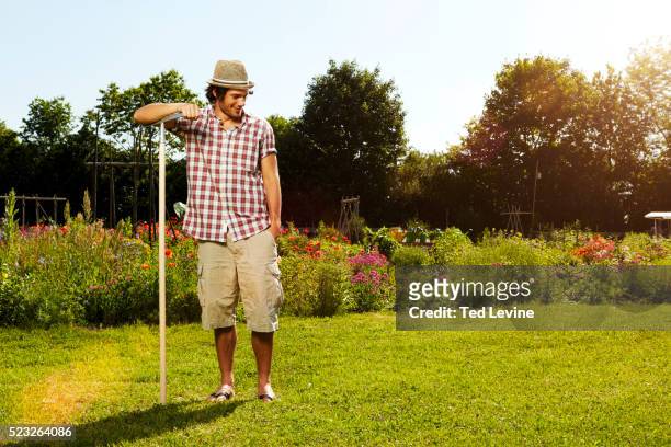 young man working in garden, bavaria, germany - rasenfläche stock-fotos und bilder