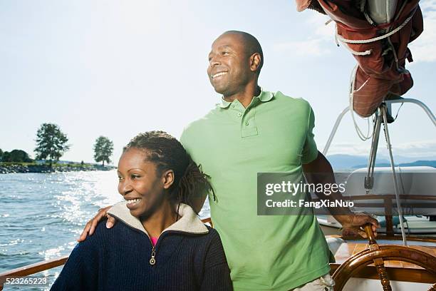 couple sitting on sailboat - male sailing stockfoto's en -beelden