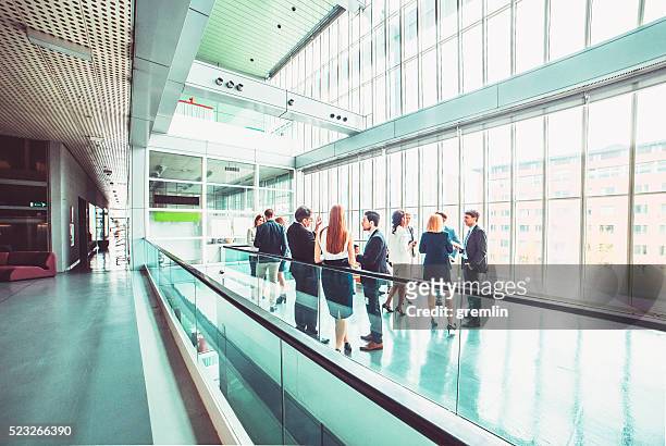 group of business people in the office building lobby - cliqueimages stock pictures, royalty-free photos & images
