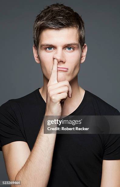 young adult man picking nose - mettersi le dita nel naso foto e immagini stock