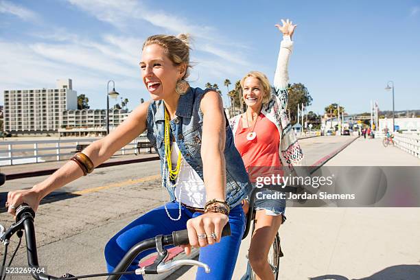 two women riding a tandem cruiser bike together, santa cruz, california, usa - tandem bicycle foto e immagini stock