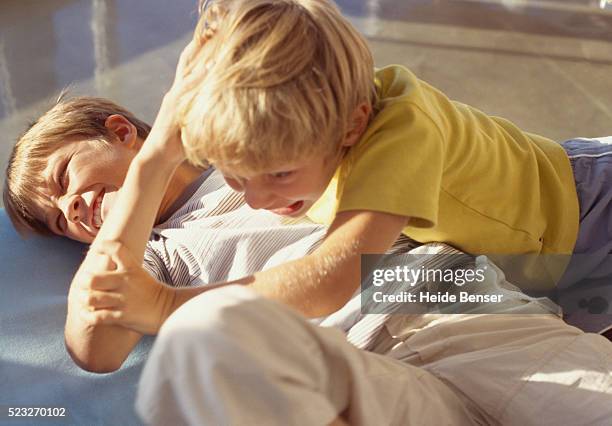 two boys fighting on the floor - arguing ストックフォトと画像