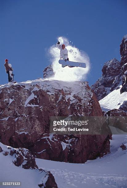 two snowboarder, one jumping off mountain, jebel toubkal, morocco - toubkal stock pictures, royalty-free photos & images