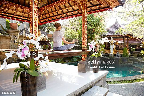 woman meditating in temple, bali, indonesia - bali temples stock pictures, royalty-free photos & images