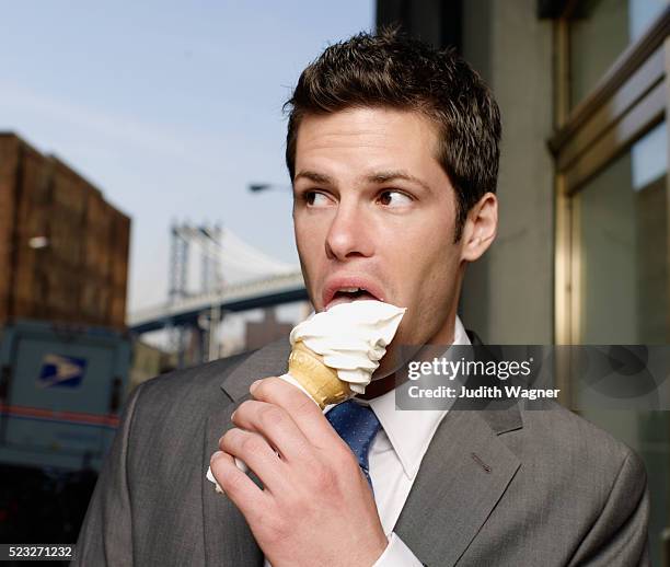 businessman eating ice cream cone - eismann stock-fotos und bilder