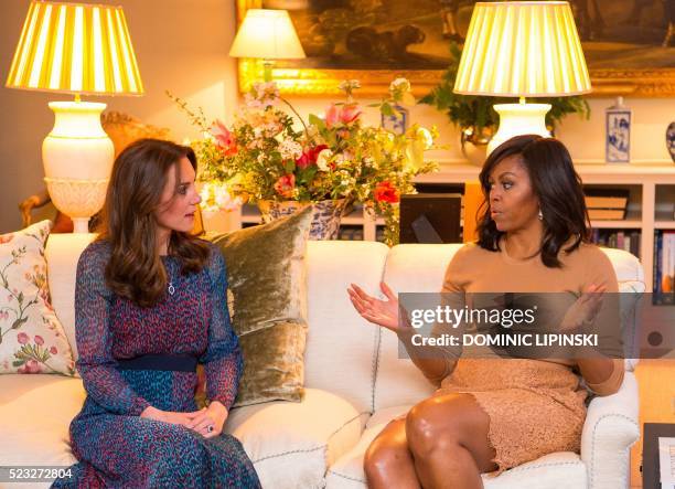 Britain's Catherine, Duchess of Cambridge talks with US First Lady Michelle Obama is a reception room at Kensington Palace in London, April 22, 2016...