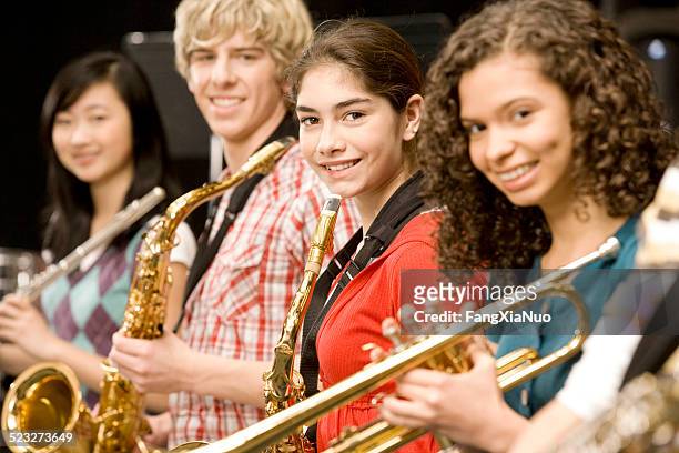 teenage girl playing saxophone in band - saxophon stock pictures, royalty-free photos & images