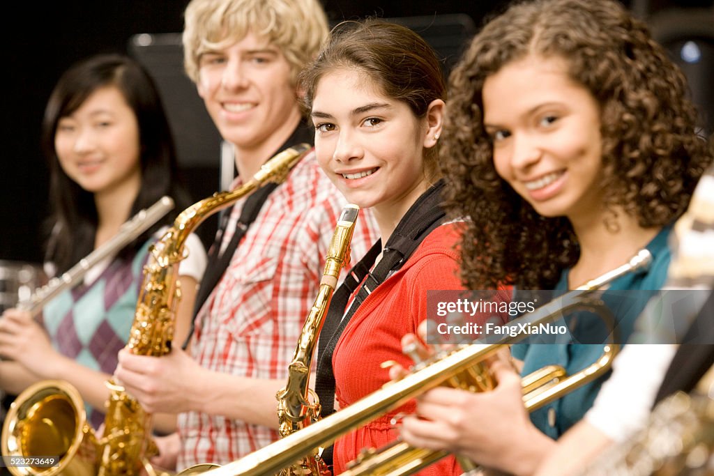 Teenage girl playing saxophone in band