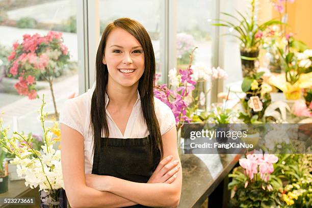 florist employee standing with flower arrangements - surrey british columbia stock pictures, royalty-free photos & images