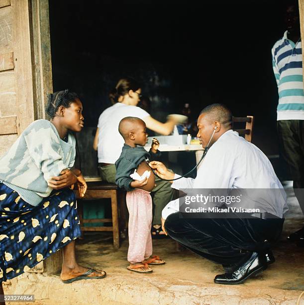 doctor treating boy in ghana - relief foto e immagini stock