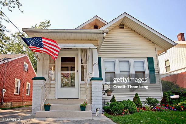 house with an american flag flying - american flag house stock pictures, royalty-free photos & images