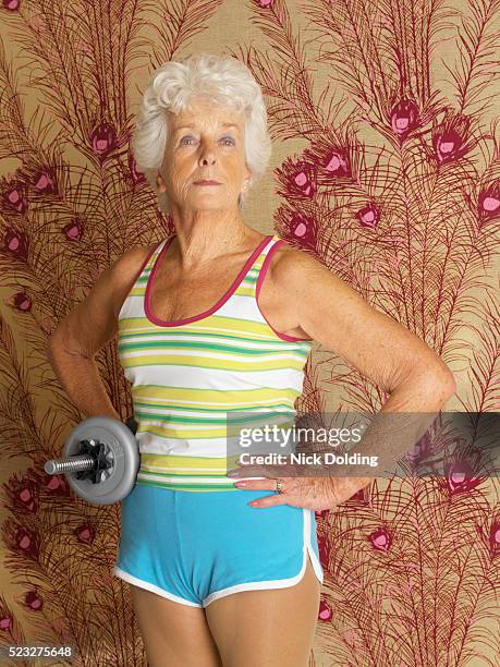 senior woman holding dumbbell - body building stock pictures, royalty-free photos & images