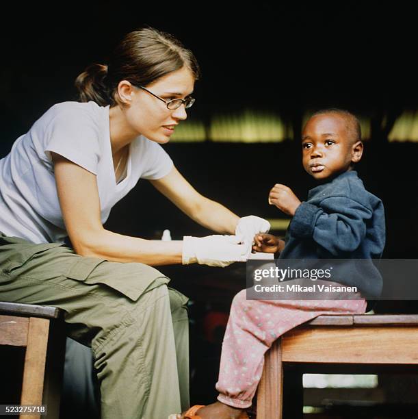 female doctor treating boy in ghana - humanitarian aid 個照片及圖片檔