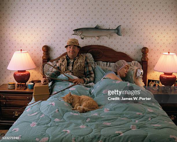 fisherman and wife in bed - tired cat stock-fotos und bilder