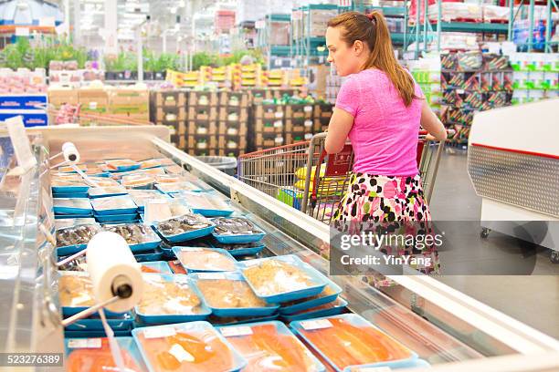 woman shopping for fresh fish seafood in supermarket retail store - large purchase stock pictures, royalty-free photos & images