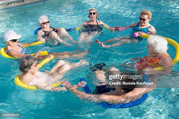 elderly couple exercising in swimming pool - aquarobics stock-fotos und bilder