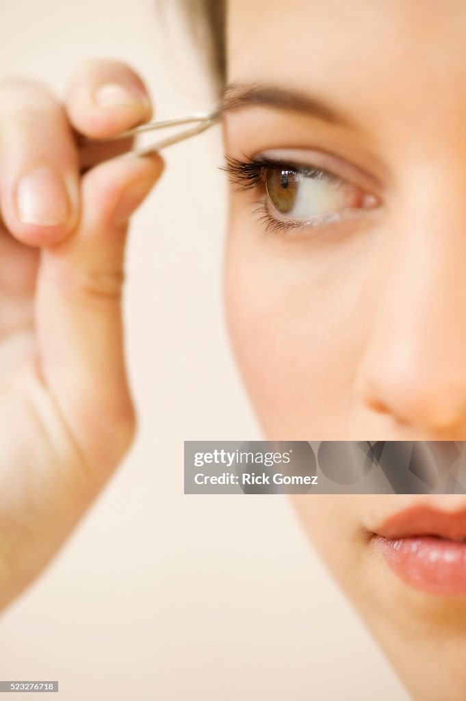 Woman Plucking Eyebrows
