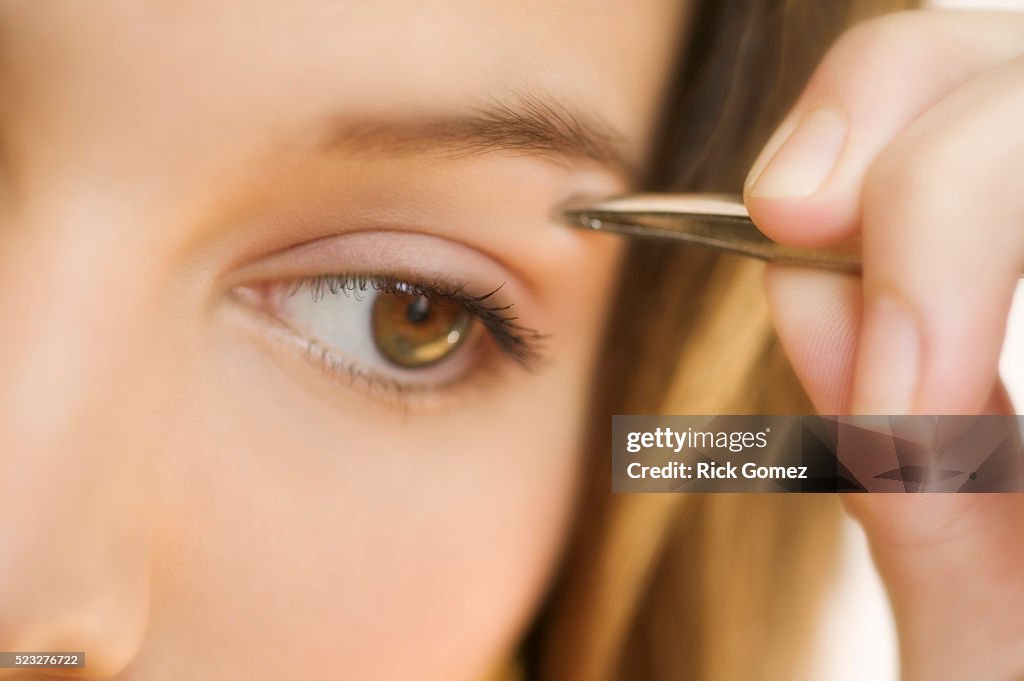 Woman Plucking Eyebrows