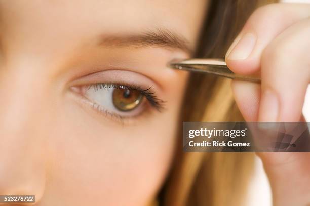 woman plucking eyebrows - tweezing eyebrows stock pictures, royalty-free photos & images