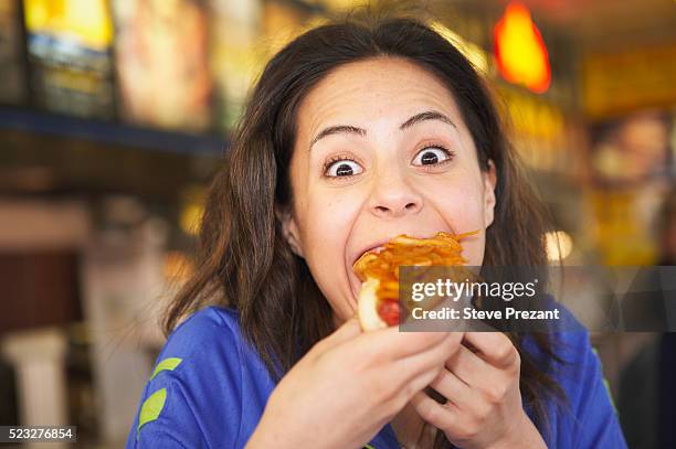 woman eating a hot dog - avarice fotografías e imágenes de stock